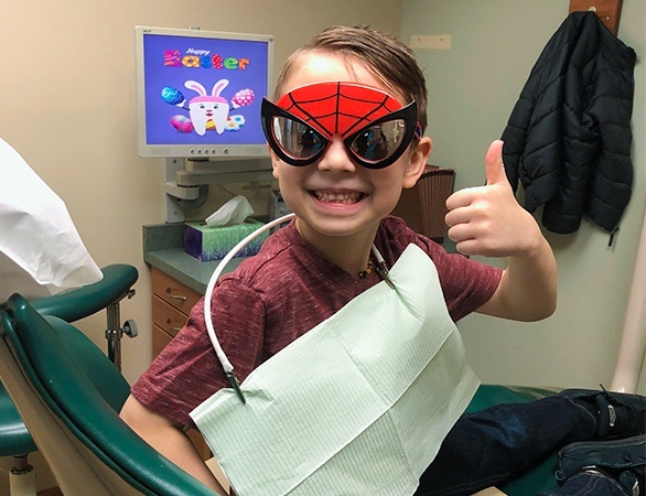 Young boy with spiderman glasses during children's dental visit