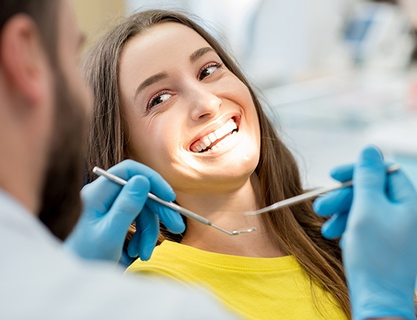 Smiling woman preventing dental emergency with preventive dental checkup