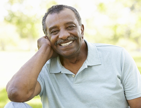Older man with partial dentures smiling