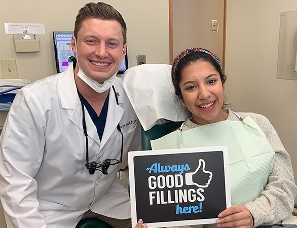 Dentist and dental patient smiling in dental treatment room