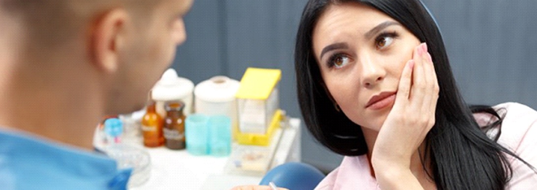 woman in pain talking to her emergency dentist in Aurora