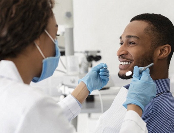 young man smiling and talking to his dentist