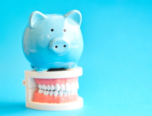 blue piggy bank sitting atop set of false teeth