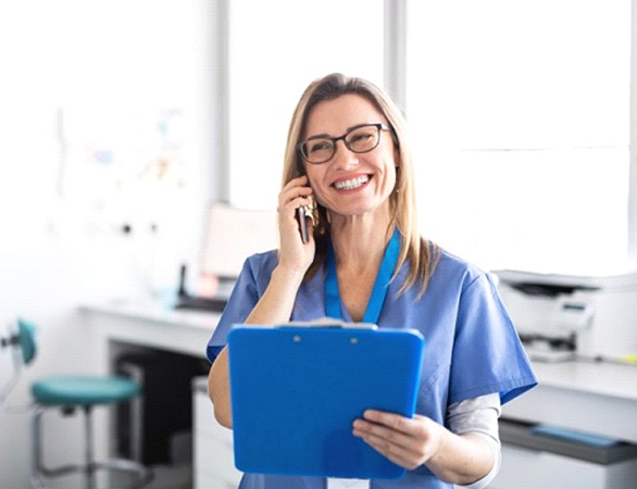 dental team member smiling while talking on the phone