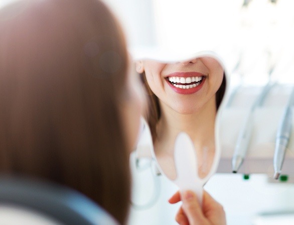Woman looking at smile after tooth-colored filling