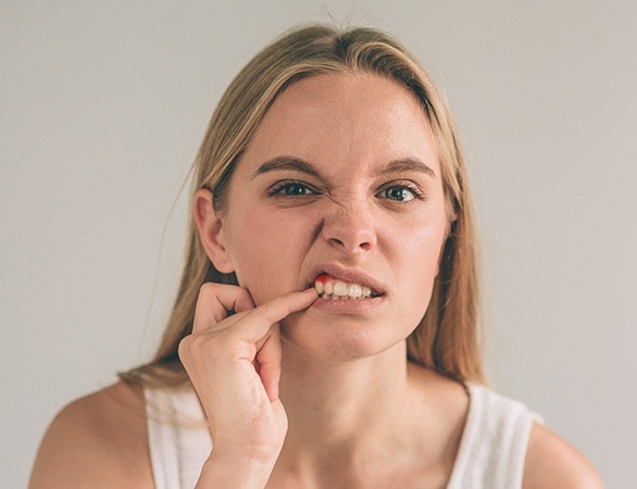 Woman in need of periodontal therapy looking at inflamed gum tissue