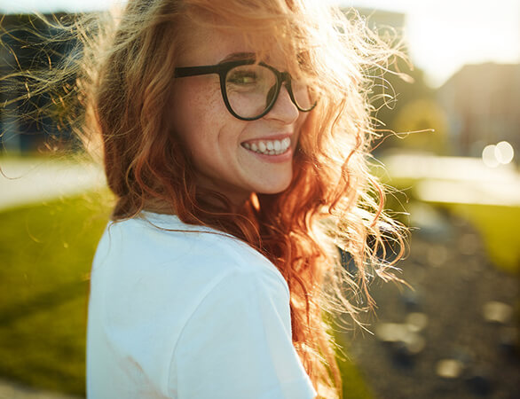 Smiling woman enjoying benefits of dental implants in Aurora