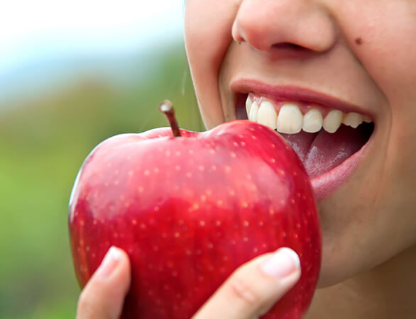 Confidently biting into apple thanks to dental implants