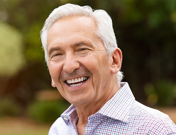 Older many smiling after dental implant tooth replacement