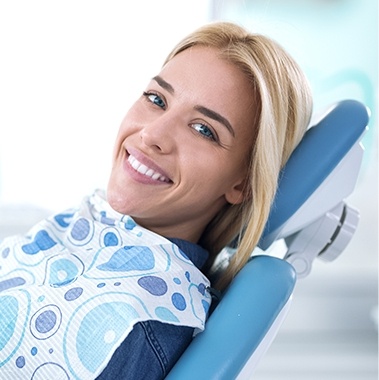 Smiling woman leaning back in dental chair