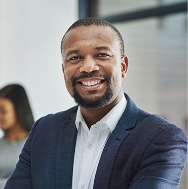 Man in dark blue suit smiling