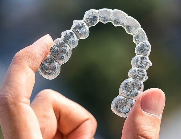 Hand holding clear aligner tray