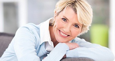 Woman smiling and leaning over back of couch