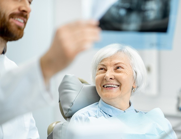 Dentist and patient looking at panoramic dental x-rays