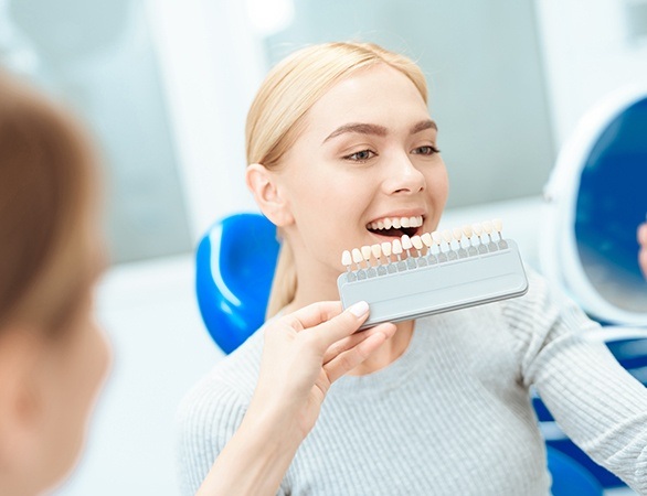 Woman looking at porcelain veneer shade chart